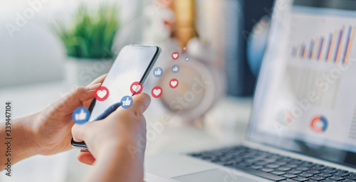 Fotografie Hand using smart phone with Social media concept