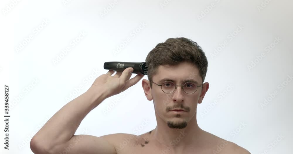 Man cuts his own hair with clipper isolated on white background timelapse Man cuts his own hair with clipper isolated on white background timelapse