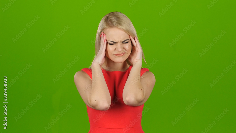Woman in red dress suffers from headache and does massage Woman in red dress suffers from headache and does massage
