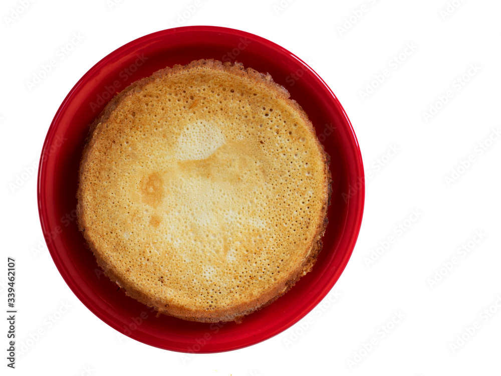 Staple of wheat golden yeast pancakes or crepes on red plate on a white background closeup Staple of wheat golden yeast pancakes or crepes on red plate on a white background closeup