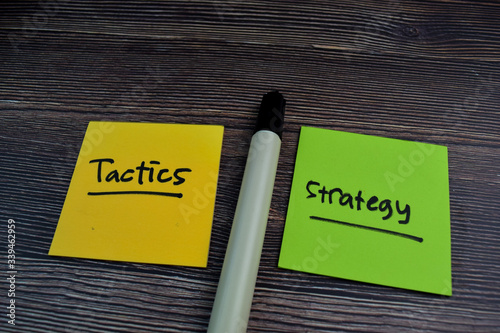 Tactics or Strategy write on sticky notes isolated on the table.
