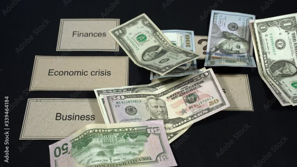 Dollar banknotes fall on a dark table. Decrease in income during quarantine. The concept of economic crisis, unemployment through Covid-19 Dollar banknotes fall on a dark table. Decrease in income during quarantine. The concept of economic crisis, unemployment through Covid-19