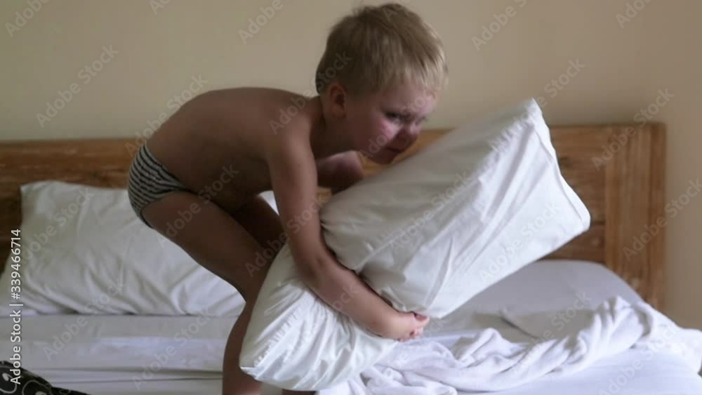 A baby boy is walking on a bed at home A baby boy is walking on a bed at home