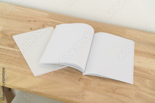 Blank catalog, magazines, book on wood background.