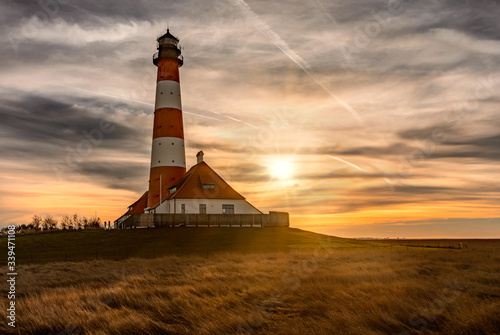 Lighthouse Westerhever near Sankt St.  Peter Ording at sunset with beautiful stunning sky and dramatic clouds