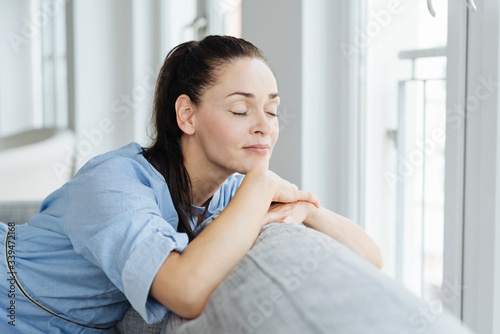 Фотография Young serene woman relaxing at home