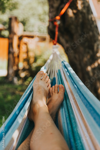 Relaxing in the hammock in the summer. Barefoot and carefree in the garden.   photo