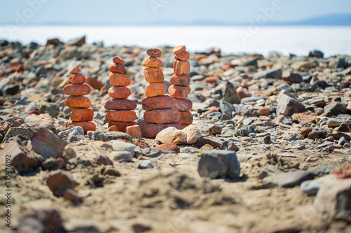 Orange stone pyramids on a sea stone beach.
