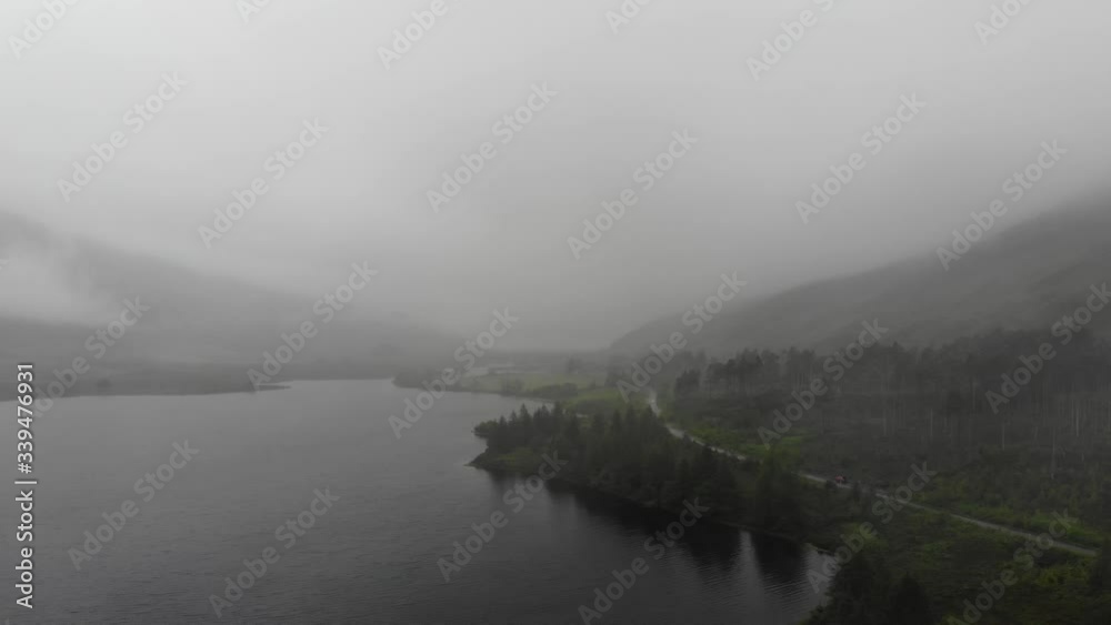 A very moody aerial shot during Scotlands North Coast 500 route capturing a very foggy, wet and rainy afternoon over a loch near Bealach Na Ba. A very moody aerial shot during Scotlands North Coast 500 route capturing a very foggy, wet and rainy afternoon over a loch near Bealach Na Ba.