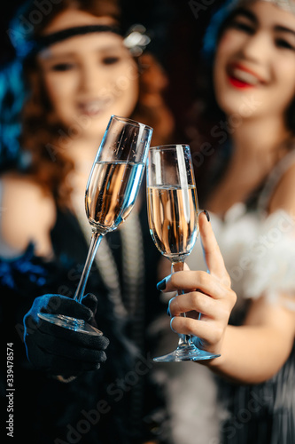 Photography Beautiful flappers women dressed in style of Roaring twenties drinking champagne
