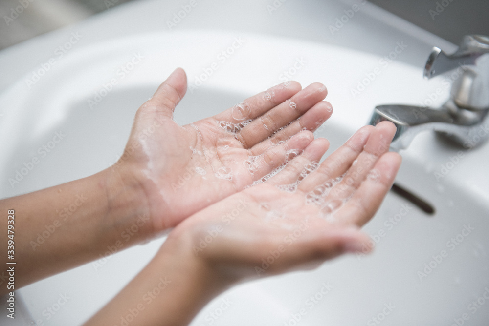 Young woman washing hands with soap over sink in bathroom, closeup Young woman washing hands with soap over sink in bathroom, closeup