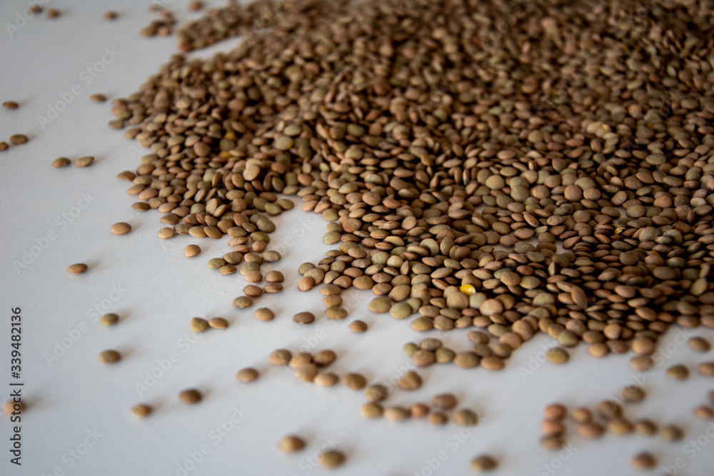 brown lentils on white surface brown lentils on white surface