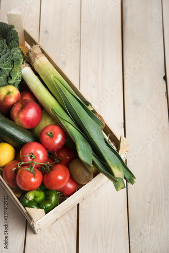 Box with vegetables and fruits on a wood background from boards. Shopping  nutrition and lifestyle