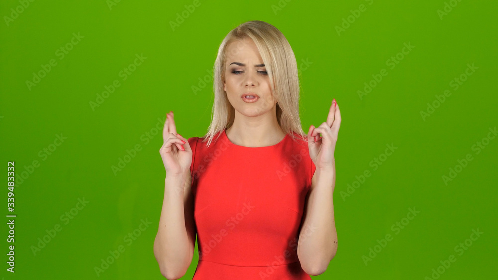 Fototapeta premium Woman crosses her fingers in two hands for good luck