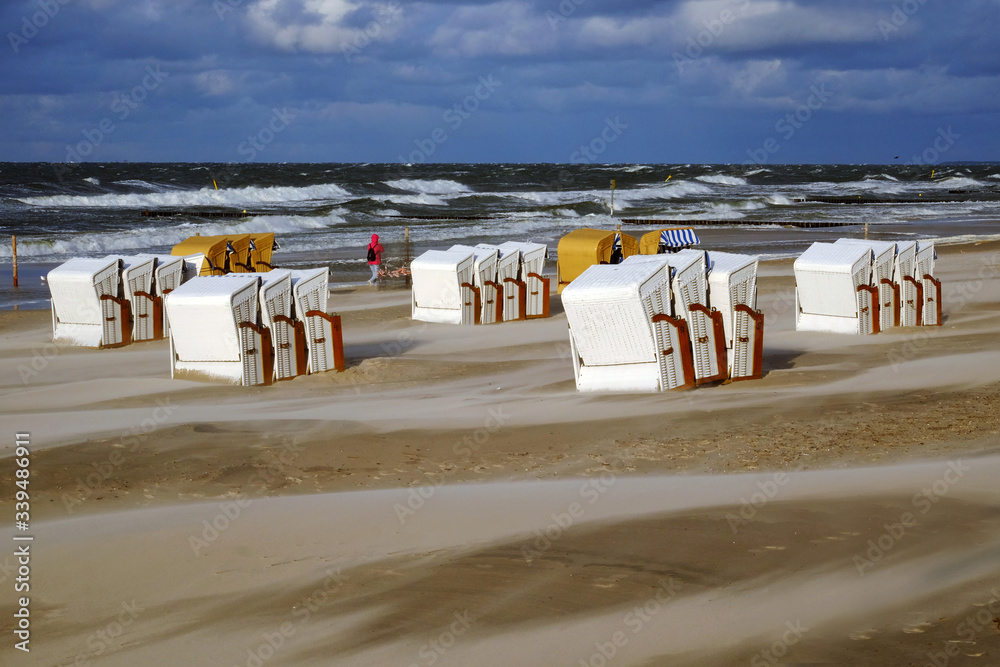 Sztorm na wybrzeżu Morza Bałtyckiego,kosze plażowe stoją na plaży w Kołobrzegu.