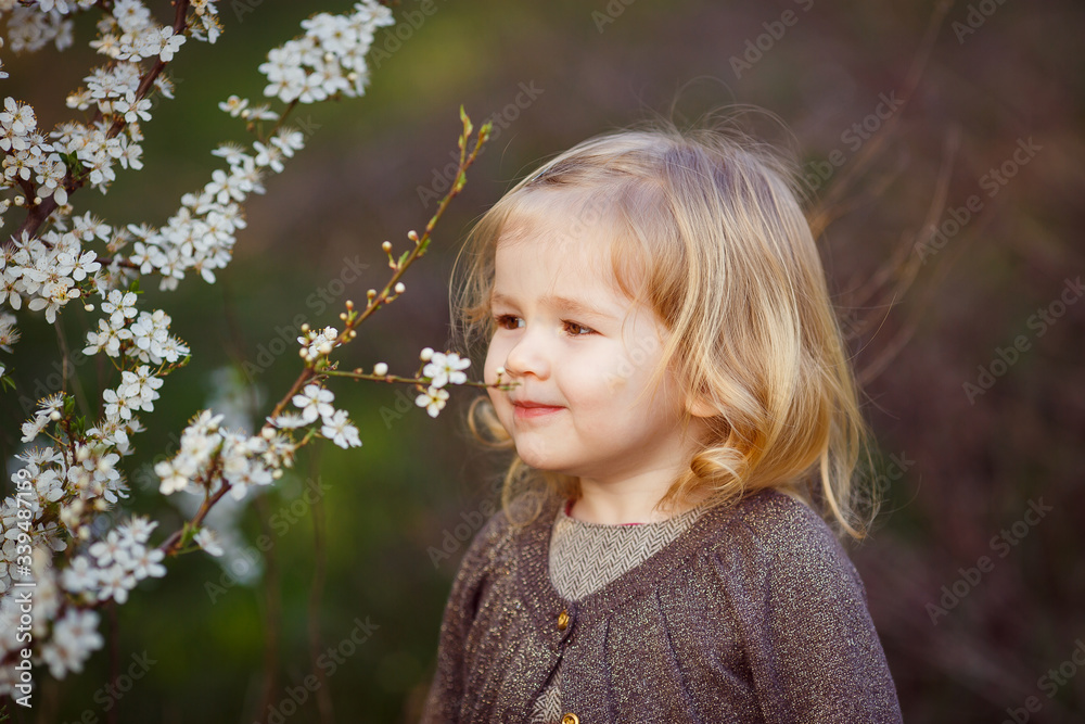 small blond girl in thickets of blooming bushes. small blond girl in thickets of blooming bushes.