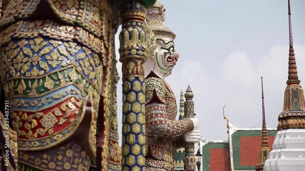 Tilting down shot of the Warrior/Demon Statues at Wat Phra Kaew temple complex and Grand Palace in Bangkok, Thailand