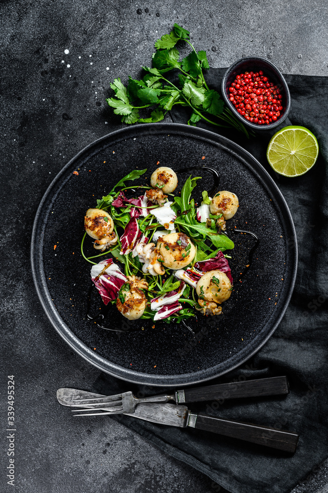 Thai salad with grilled squid and arugula. Black background. Top view