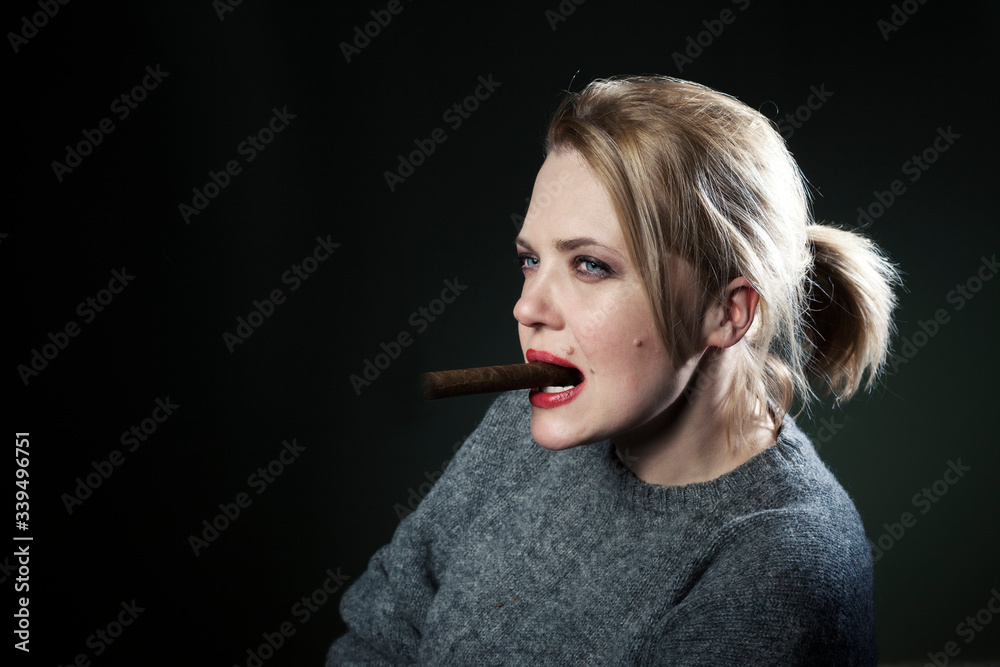 Obraz premium Woman with a cigar. The beautiful blonde. Black background