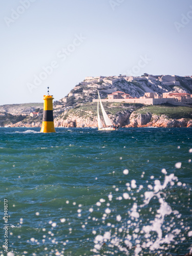 Single Sailing Boat in the Ocean on a sunny day at Vallons des Auffes in Marseille, France photo