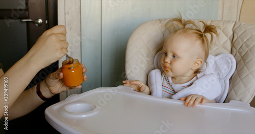 Caucasian mother feeding baby with spoon