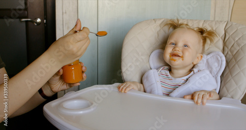 Caucasian mother feeding baby with spoon