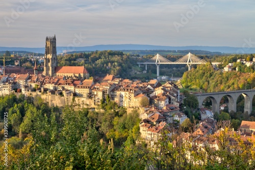 Panoramic view of cathedral of St. Nicholas, new Poya and old Zaehringen bridge by night, Fribourg, Switzerland, HDR photo