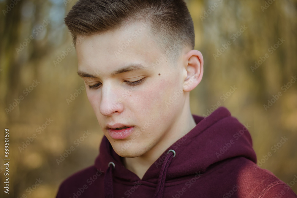 Closeup portrait of a young guy. The student. The young man is smiling. Emotion Fashionable men's hairstyle. The young man is looking down. Closeup portrait of a young guy. The student. The young man is smiling. Emotion Fashionable men's hairstyle. The young man is looking down.