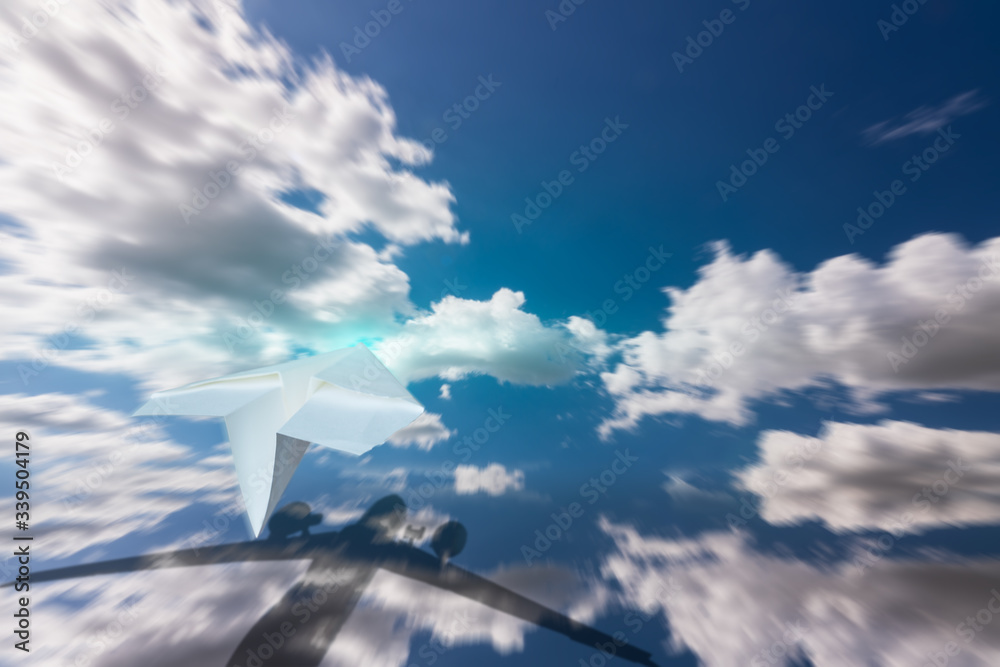 paper rocket flying on the clouds and show big plane shadow reflected on the ocean, think big concept paper rocket flying on the clouds and show big plane shadow reflected on the ocean, think big concept