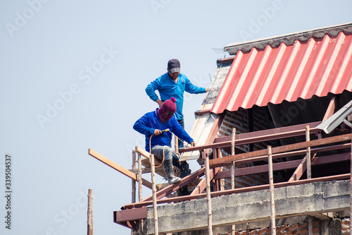 Two men  working on replacing the roof