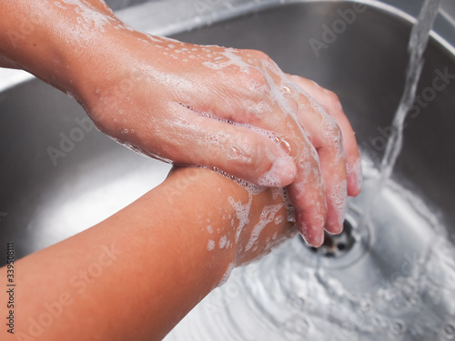  Image of a man washing his hands with soap to prevent corona virus.