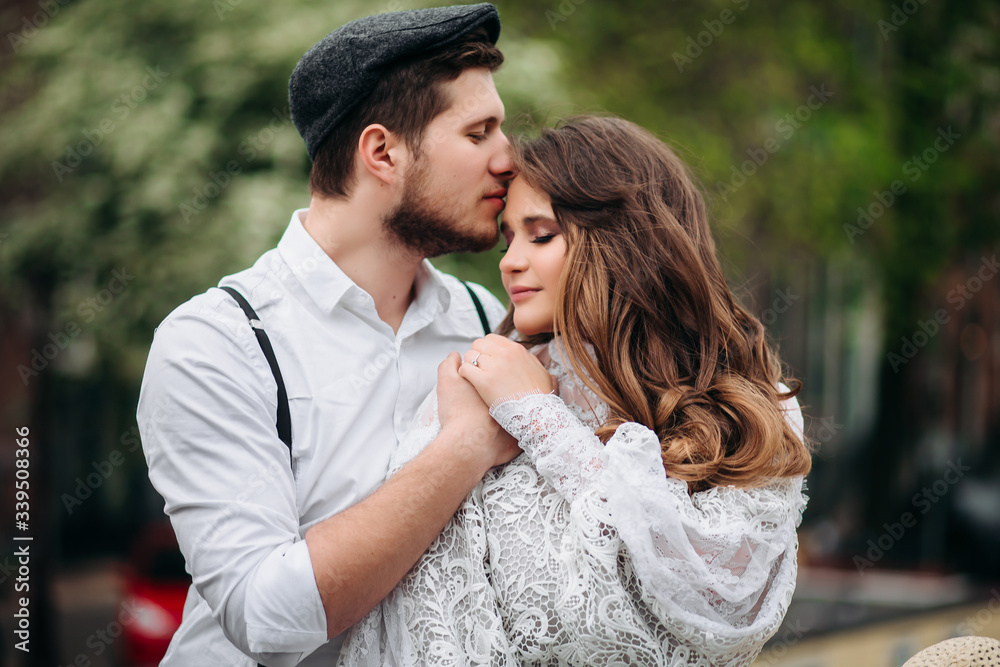 Fototapeta premium man kissing his girlfriend on the forehead