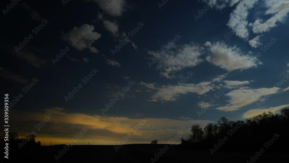 Time lapse panning shot of city lights on the clouds at night with planes flying across the sky