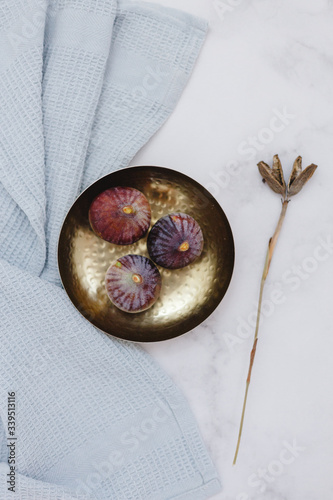 Fresh figs on gold bowl marble background