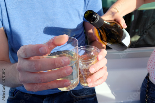 Pouring white wine into cups during a picnic