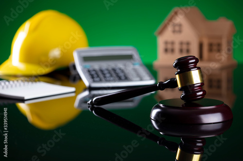 Labour law and builiding law concept.  Gavel and yellow crash helmet on the shining lawer desk. photo