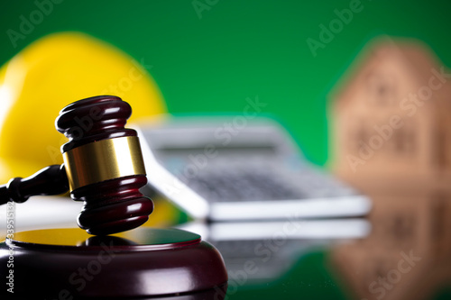 Labour law and builiding law concept.  Gavel and yellow crash helmet on the shining lawer desk. photo