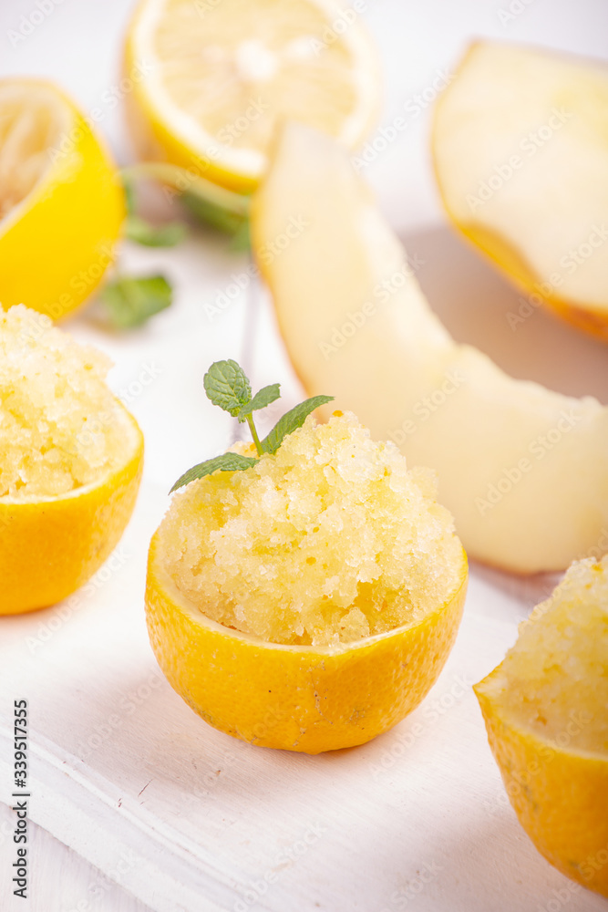Melon and lemon fruit sorbet. Summer refreshing dessert in half of lemon fruit peel over on white background.