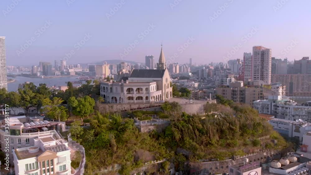 Rotating aerial point of interest shot of Chapel of Our Lady of Penha, hilltop church in Macau, with Macau city in background Rotating aerial point of interest shot of Chapel of Our Lady of Penha, hilltop church in Macau, with Macau city in background