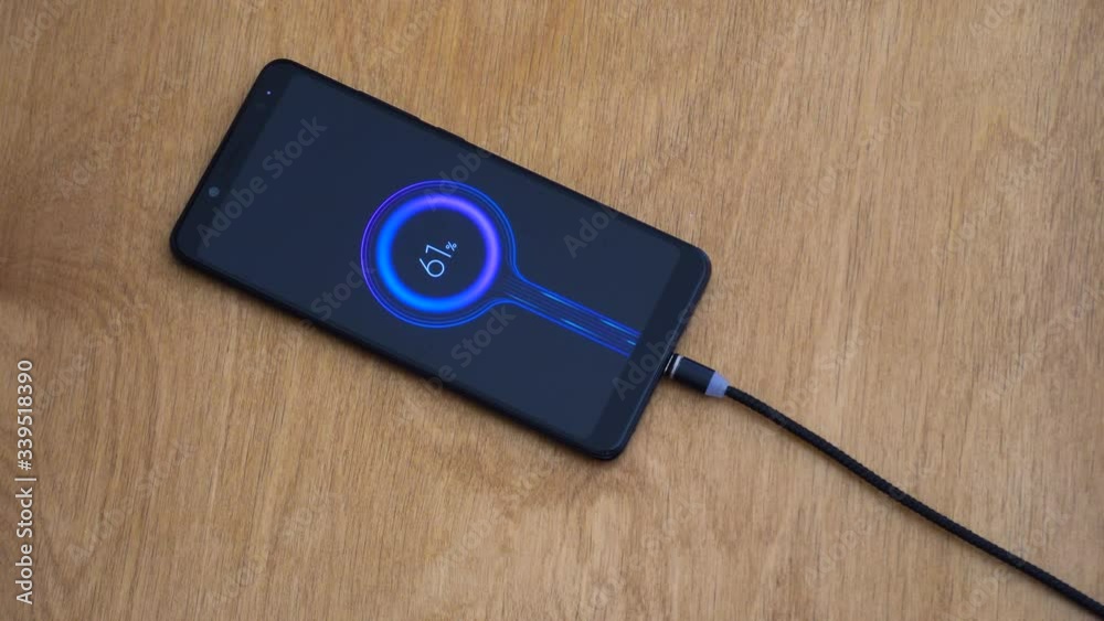 Magnetic charge wire hunts and connects to smartphone to recharge, close up Magnetic charge wire hunts and connects to smartphone to recharge, close up