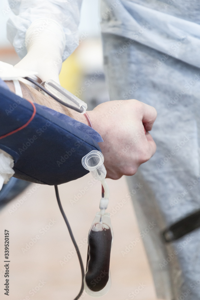 Donor donates blood from a vein in the presence of a doctor