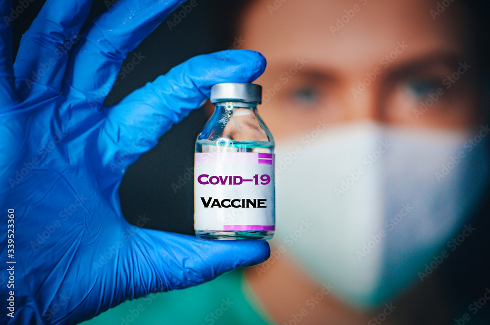 Coronavirus Covid-19 Protection and Vaccine. Female doctor, protect mask, portrait, Medicine bottle for injection medical glass vials for vaccination. Tittle Coronavirus Covid-19 Protection and Vaccine. Female doctor, protect mask, portrait, Medicine bottle for injection medical glass vials for vaccination. Tittle