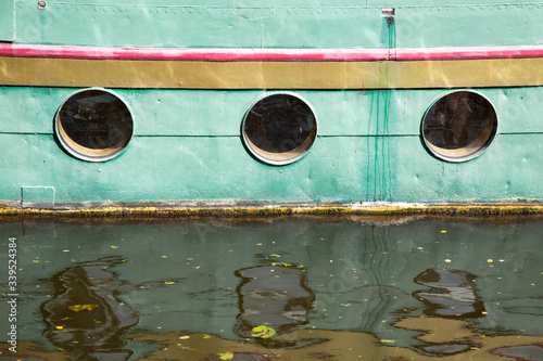 Drei Bullaugen eines Schiffes am Anleger im Hafen photo