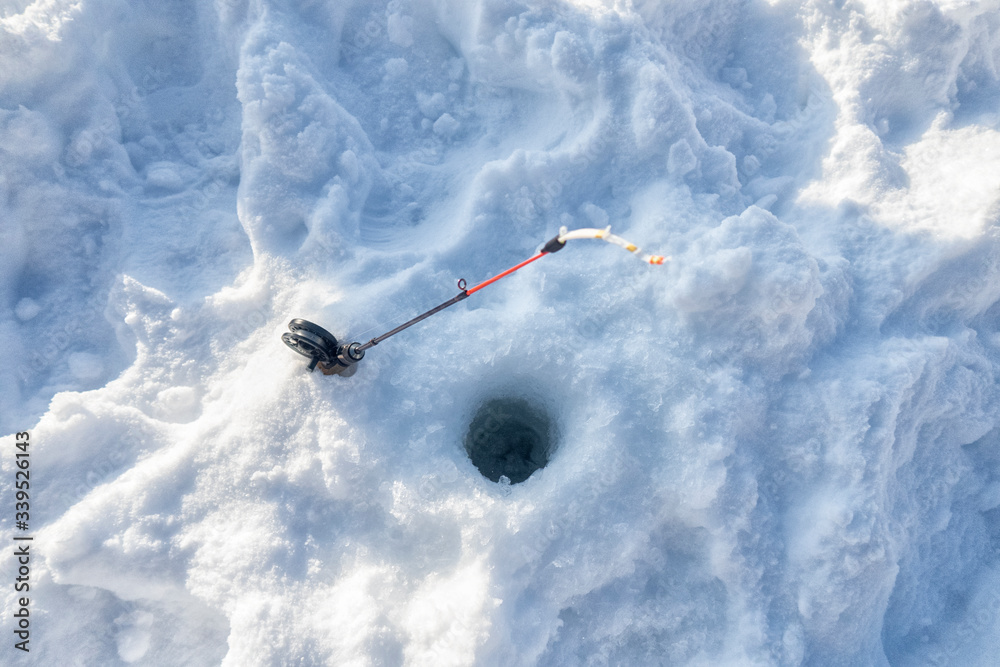 A black reel and gold rod for ice fishing. A black reel and gold rod for ice fishing.