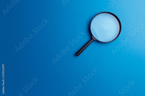 Concept information search. Magnifying glass on classic blue background. Top view. Flat lay. Copy space. Minimal creative concept. Trendy color. Searching information data on internet
