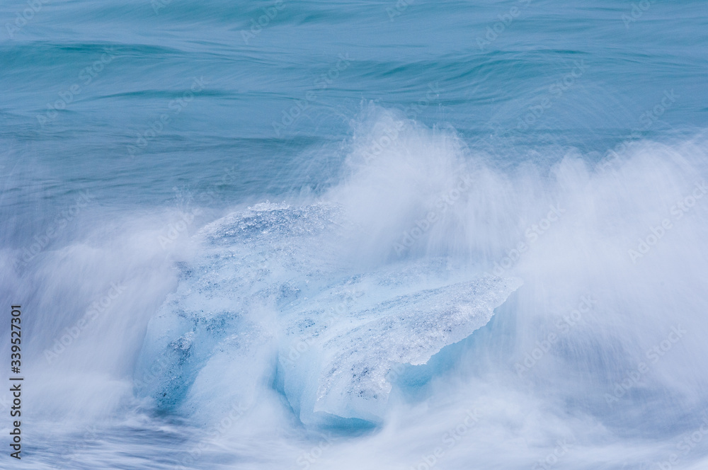 Fototapeta premium Wave splashing against glacier ice outside Jokulsarlon, Iceland.