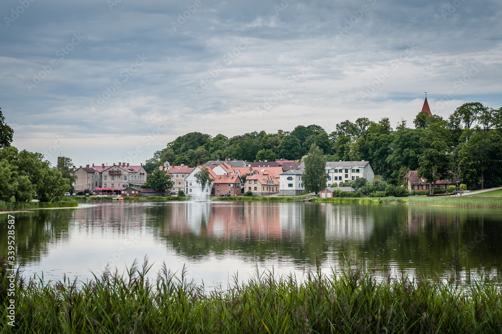 Fototapeta premium View of old town and small lake with fountain. Cityscape in summer rain. Talsi, Latvia.
