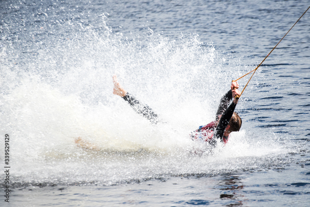 Obraz premium The guy in a thermosuit rides a board on water in the local river. Modern sport.