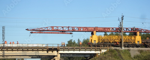 Russian rail loader crane on a railway bridge, replacement of rails, repair of the trackbed