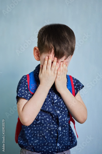 schoolboy crying on a blue background